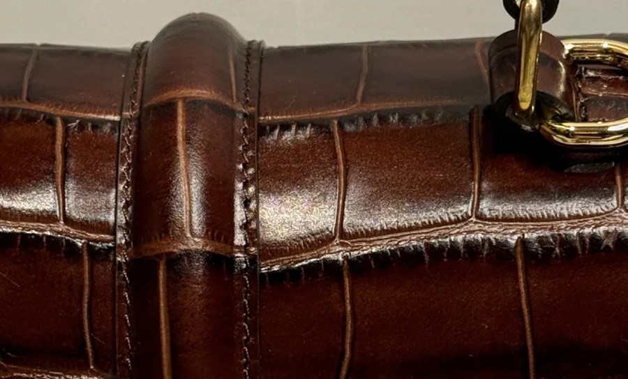The handle fitting against the grained leather